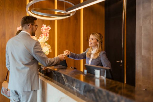 Female hotel receptionist assisting business couple for checking in